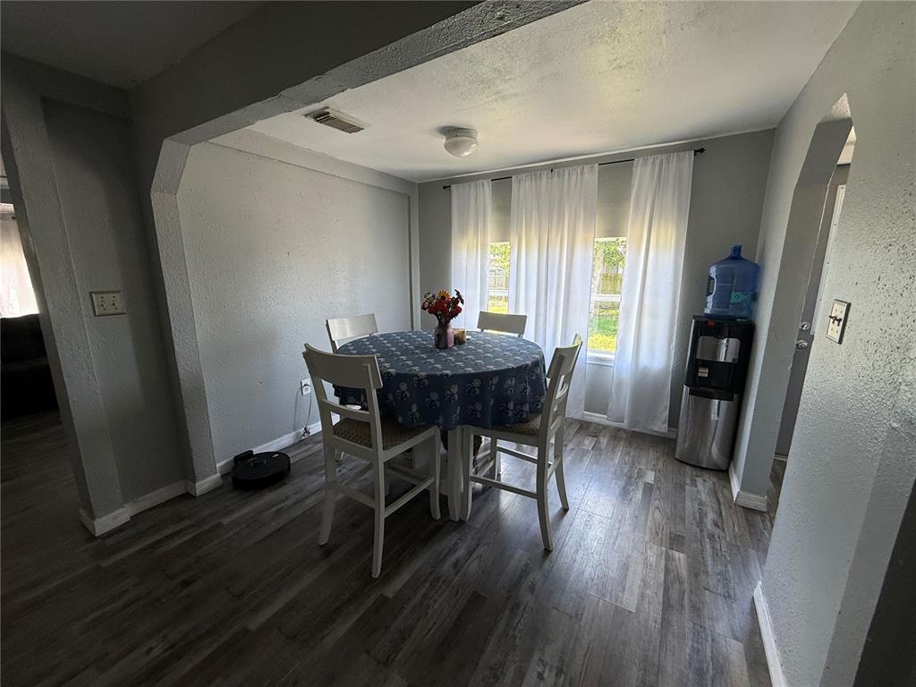 A dining area features a round table with four chairs, gray flooring, and white curtains — 4233 OLD US HIGHWAY 41, RUSKIN, FL