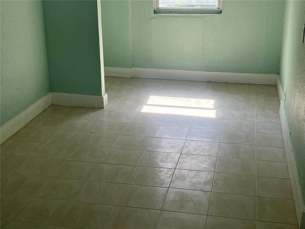 A small room with light green walls and light-colored square floor tiles — 2002 E 33RD AVENUE, TAMPA, FL