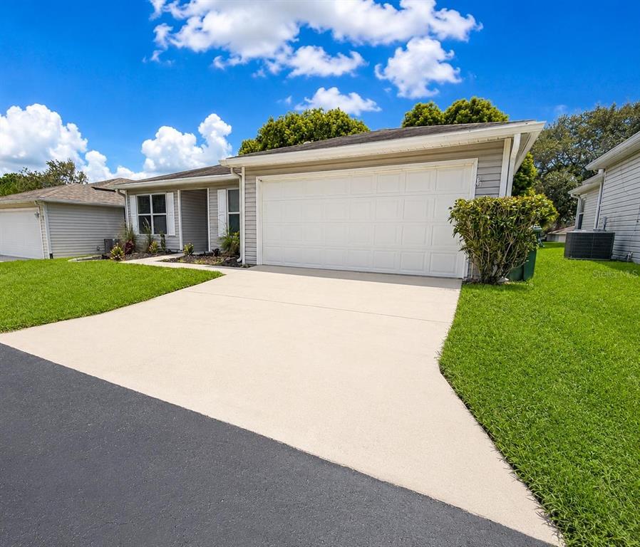 A single-story house with light gray siding, a white garage door, and a concrete driveway — 29204 PRINCEVILLE DRIVE, SAN ANTONIO, FL