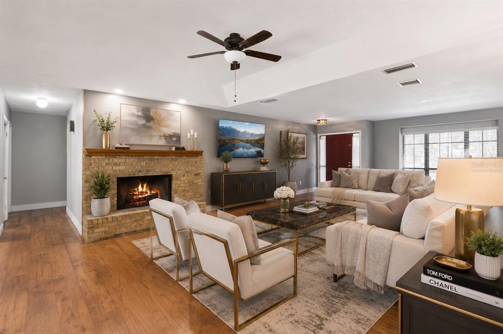A living room features a brick fireplace, two armchairs, a sofa, and a ceiling fan — 432 BURNT TREE LANE, APOPKA, FL