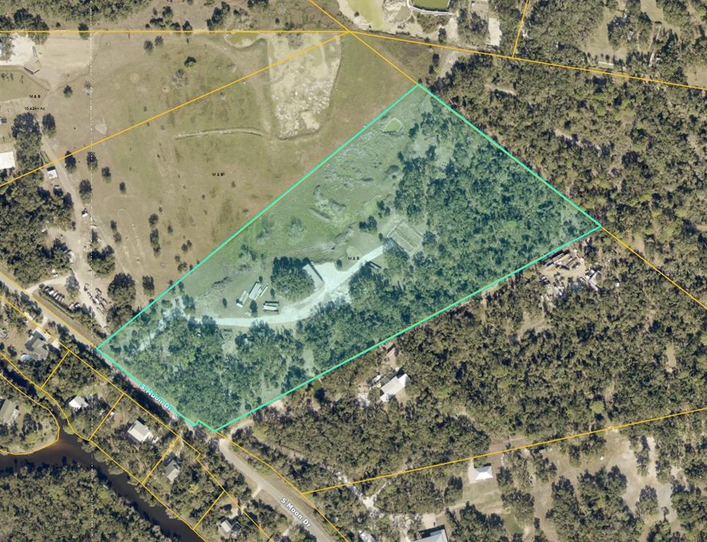 An aerial view shows a large, partially wooded plot of land outlined in teal — S MOON DRIVE, VENICE, FL