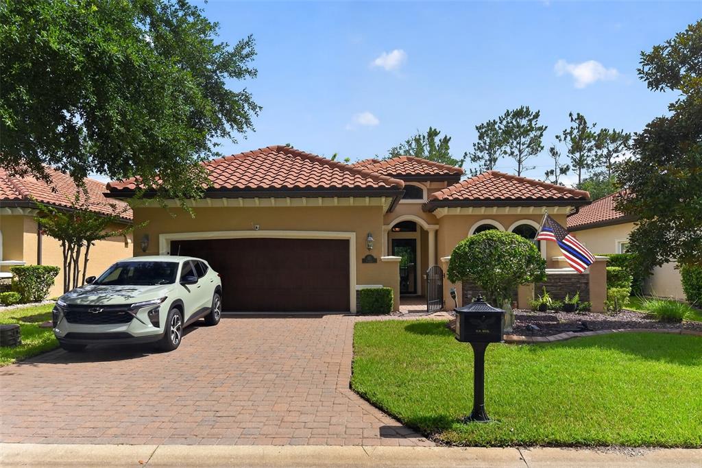 A single-story house with a tile roof, two-car garage, and a paved driveway — 110 VIA ROMA, ORMOND BEACH, FL