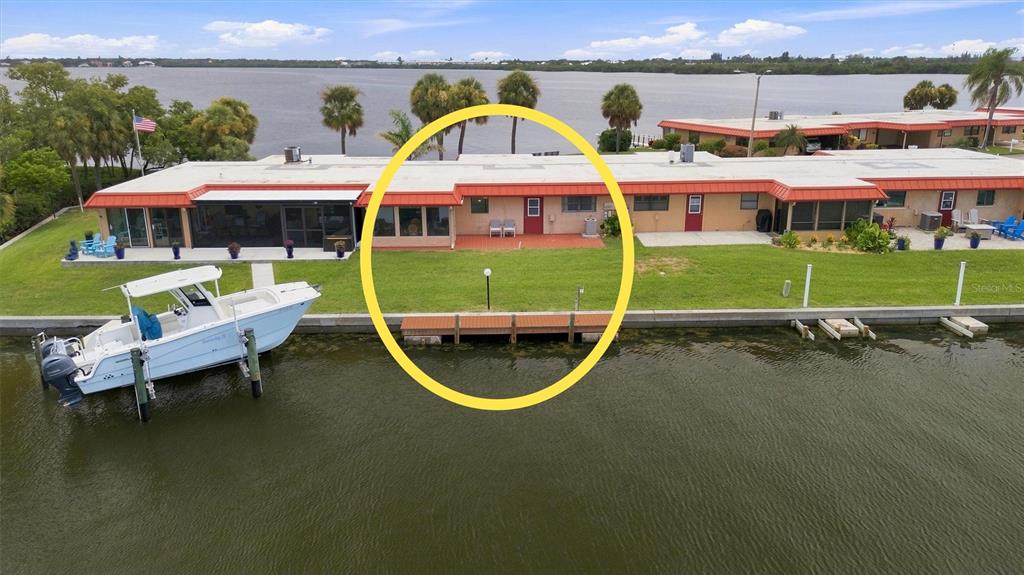 An aerial view shows a waterfront townhouse unit with a patio and private boat dock — 3840 CATALINA DRIVE, BRADENTON, FL