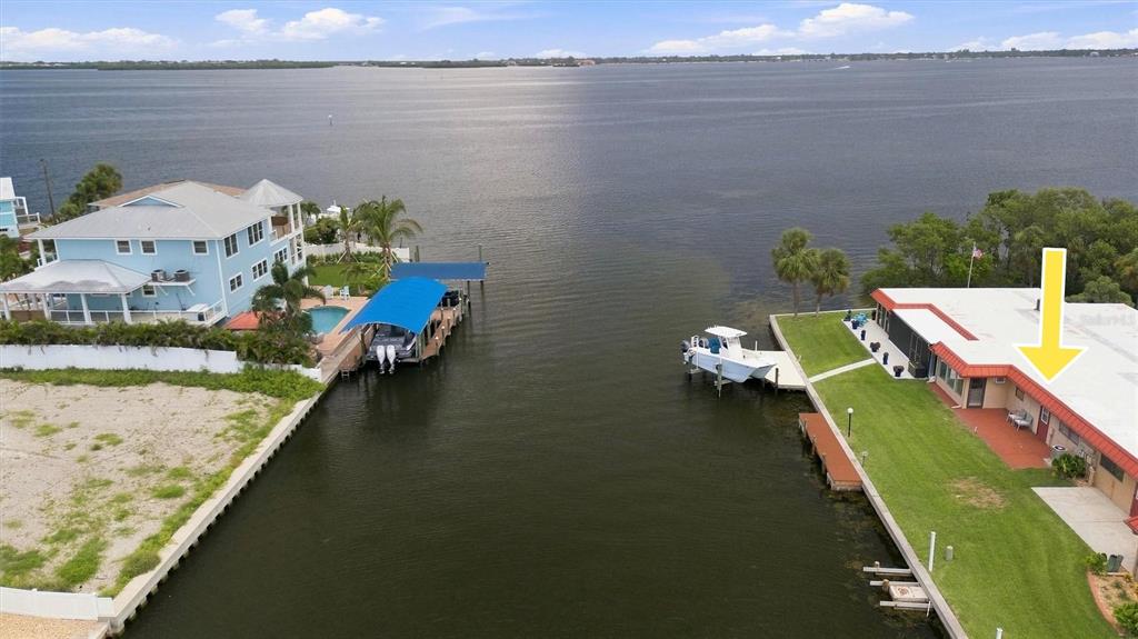 An aerial view shows two waterfront houses separated by a canal leading to a bay — 3840 CATALINA DRIVE, BRADENTON, FL