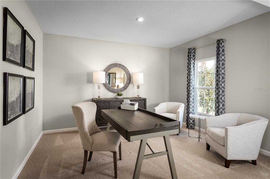 A home office features a dark wood desk, two armchairs, a console table, and wall art — 11464 SE 77TH AVENUE, BELLEVIEW, FL