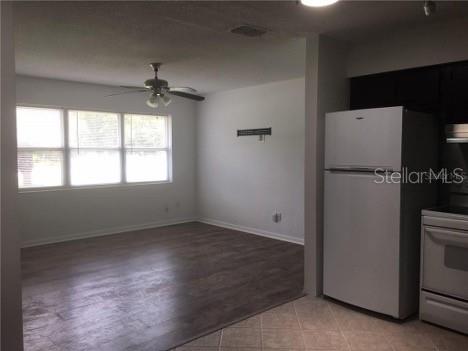 A view from a tiled kitchen looking into a living room with wood-look flooring — 22201 SW BEACH BOULEVARD, DUNNELLON, FL