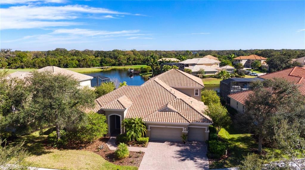 An aerial view of a suburban house with a tiled roof and attached garage — 1023 RAINBOW COURT, BRADENTON, FL