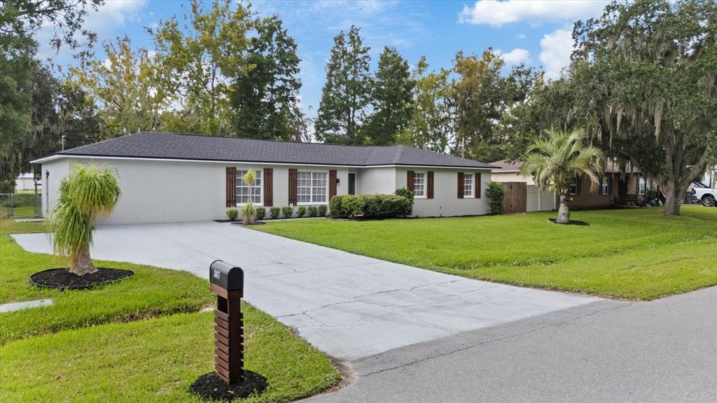A single-story house with a gray exterior, dark roof, and a concrete driveway — 3417 LORI LANE S, LAKELAND, FL