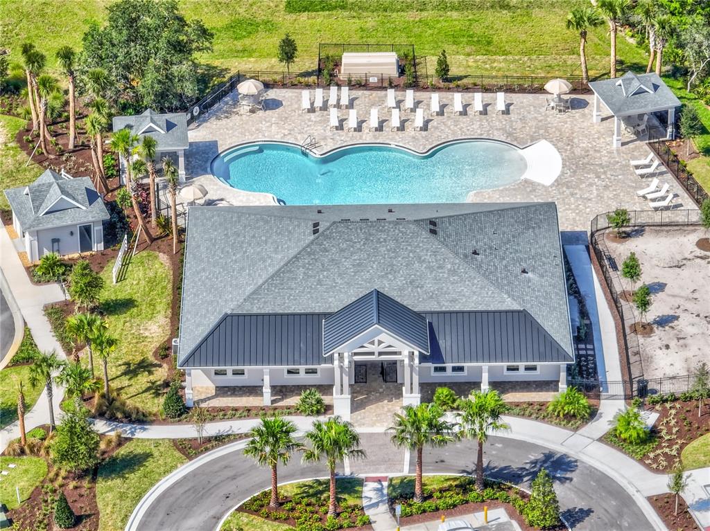 An aerial view shows a community clubhouse with a pool, patio, and surrounding landscaping — 975 MEGANO BOULEVARD, DELAND, FL