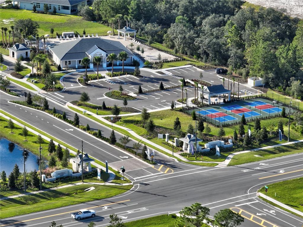 An aerial view shows a community clubhouse with a parking lot and tennis courts — 975 MEGANO BOULEVARD, DELAND, FL