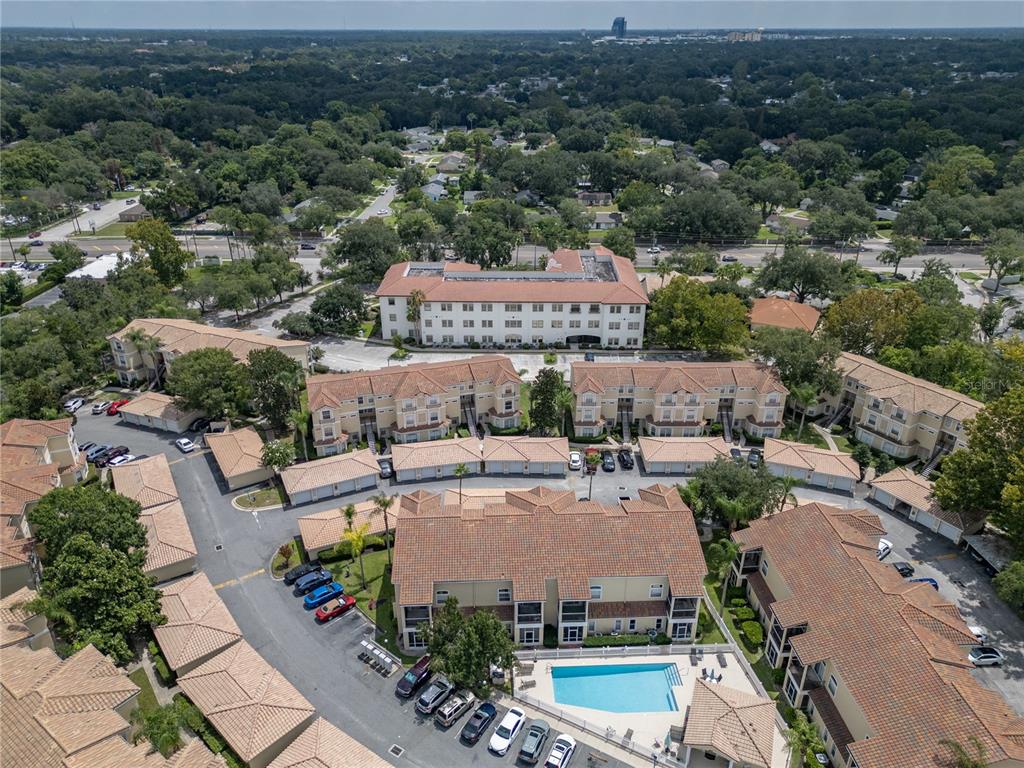 An aerial view shows a multi-story apartment complex with a swimming pool and parking area — 673 SANDY NECK LANE UNIT 103, ALTAMONTE SPRINGS, FL