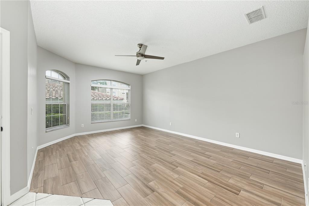 An empty room with light gray walls, wood-look tile flooring, and a ceiling fan — 673 SANDY NECK LANE UNIT 103, ALTAMONTE SPRINGS, FL