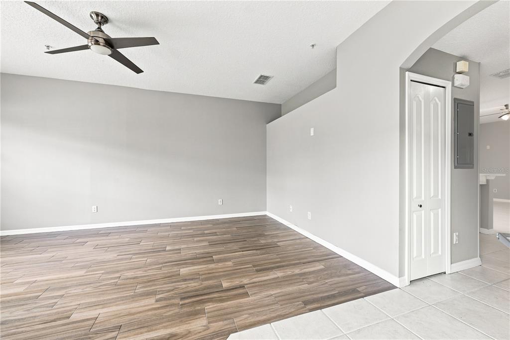 An empty room features wood-look tile flooring, gray walls, and a ceiling fan — 673 SANDY NECK LANE UNIT 103, ALTAMONTE SPRINGS, FL