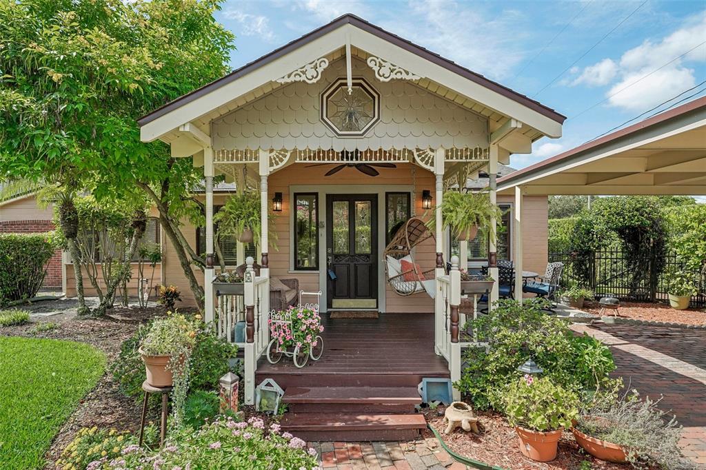 A front porch with a wooden deck, decorative trim, and a hanging chair on a house — 1020 VENETIAN AVENUE, ORLANDO, FL