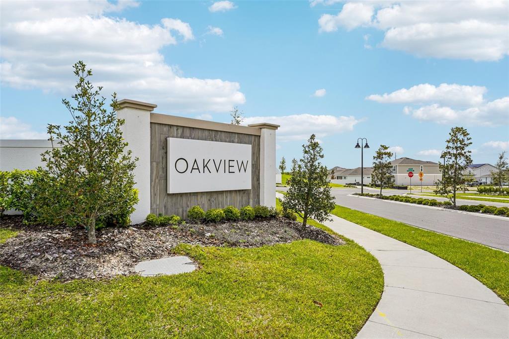 A neighborhood entrance sign for Oakview stands beside a sidewalk and a paved road — 4507 LAUREL SITE LOOP, APOPKA, FL