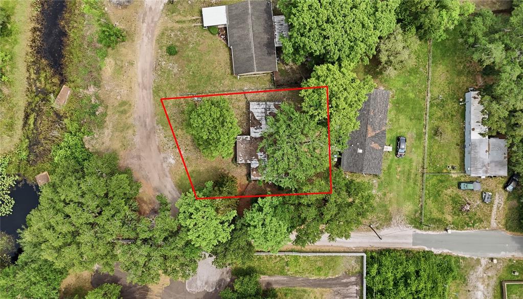 An aerial view shows a house with a weathered roof surrounded by trees and grass — 4791 SUNSET ROAD, ST CLOUD, FL