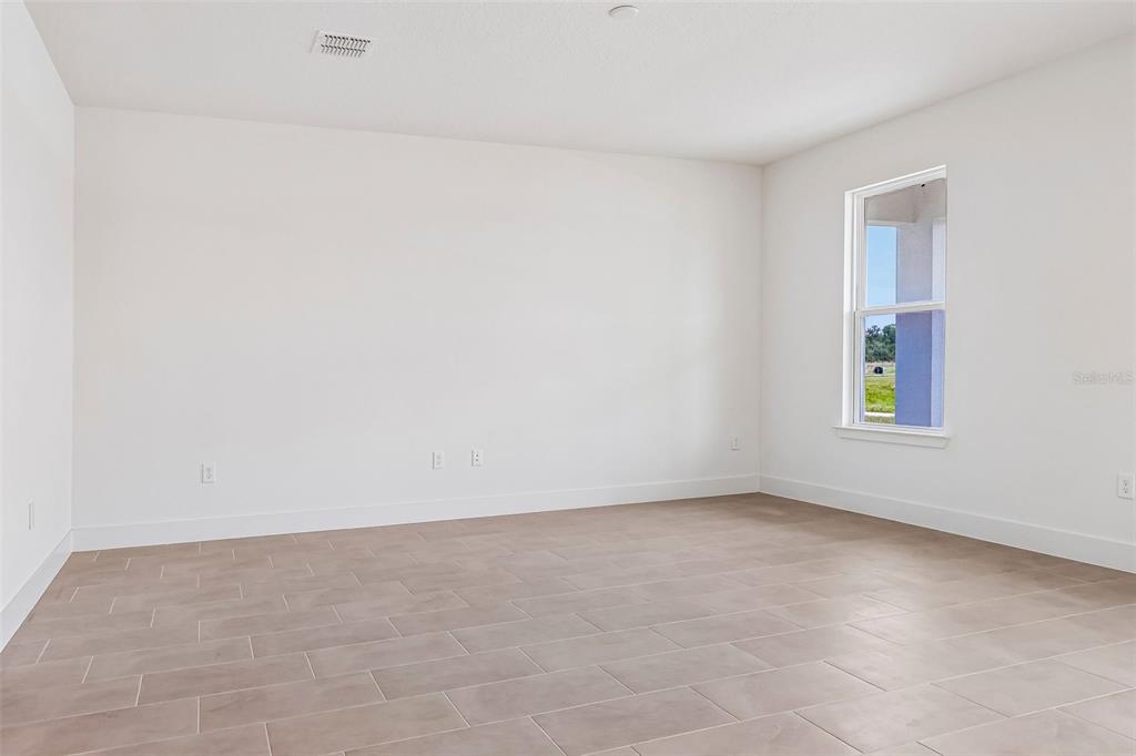 An empty room with white walls, light tile flooring, and a single window — 5024 SALADO DRIVE, ST CLOUD, FL