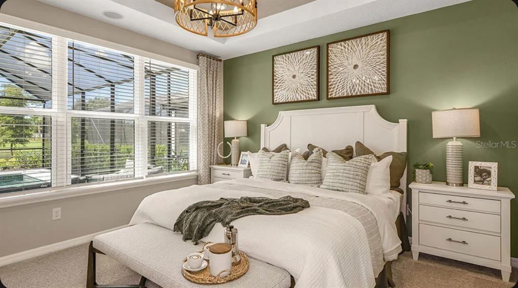 A bedroom features a white bed, sage green accent wall, and a large window — 5079 LOST KEY PLACE, ST CLOUD, FL