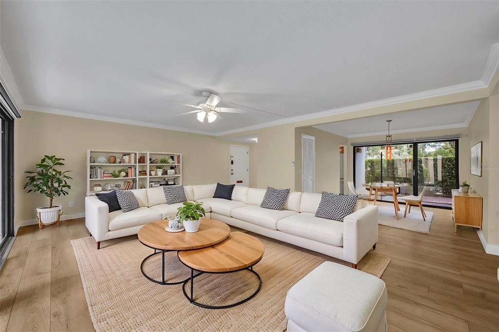 A sunroom with black-framed windows, tile flooring, white wood-paneled walls, and outdoor lawn views — 249 W LAKE FAITH DRIVE UNIT 205, MAITLAND, FL
