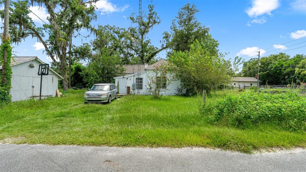 A white house with a detached garage and a car parked on an overgrown lawn — 5698 NAVARRE AVENUE, HAMPTON, FL