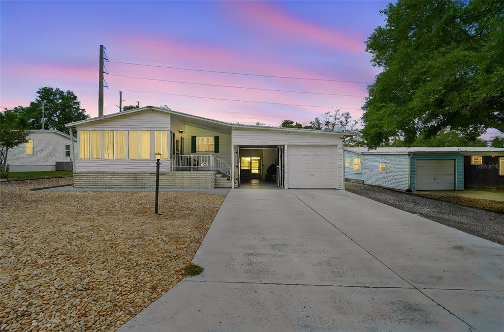 A white single-story house with a concrete driveway, attached garage, and a gravel front yard — 30 FLORENCE BOULEVARD, DEBARY, FL