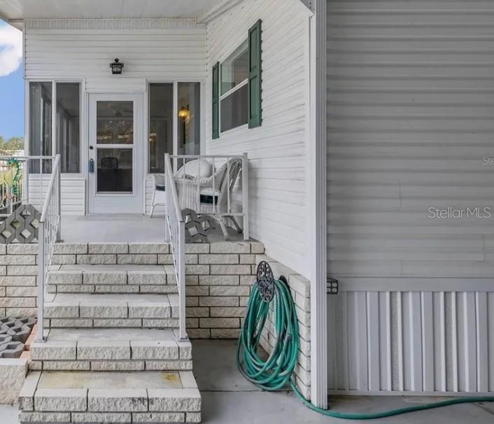 A white mobile home features a brick-stepped entrance leading to a small covered porch — 30 FLORENCE BOULEVARD, DEBARY, FL