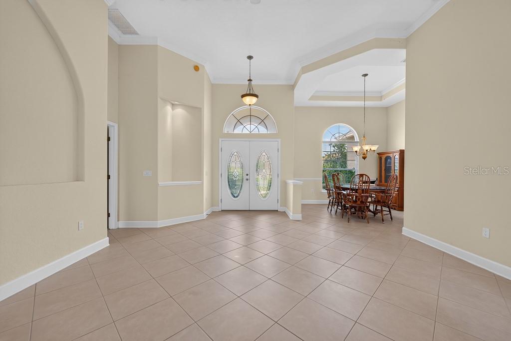 A spacious foyer with tile flooring leads to a dining area and double front doors — 306 TERRANOVA BOULEVARD, WINTER HAVEN, FL