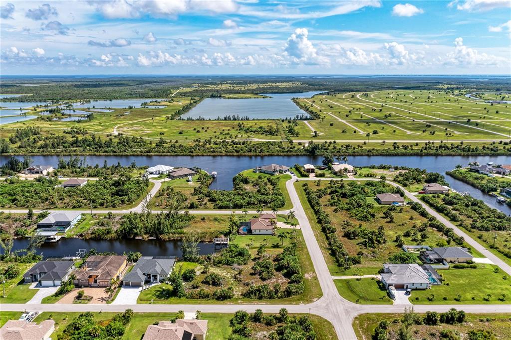 An aerial view shows residential houses situated along canals in a rural, undeveloped landscape — 10453 POUGHKEEPSIE CIRCLE, PORT CHARLOTTE, FL