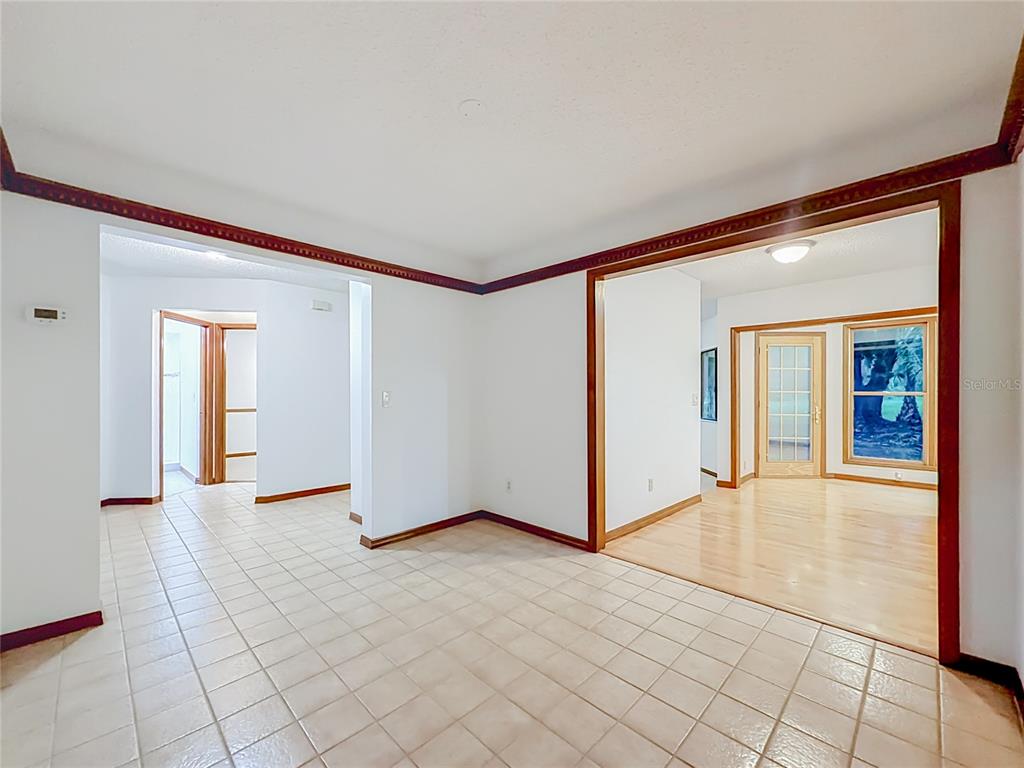 An interior view shows a tiled room transitioning into a wood-floored space with wood trim — 662 NIGHTHAWK CIRCLE, WINTER SPRINGS, FL