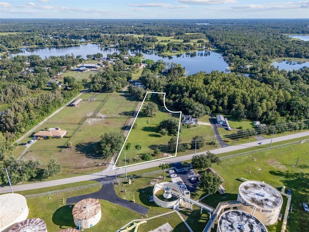 An aerial view shows a vacant lot outlined in white next to a water treatment facility — 0 MILAM DRIVE, ODESSA, FL