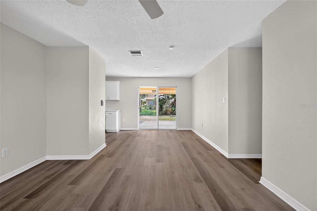 An empty room with wood-look flooring, light gray walls, and sliding glass doors to outside — 1856 JACKSON AVENUE, MELBOURNE, FL