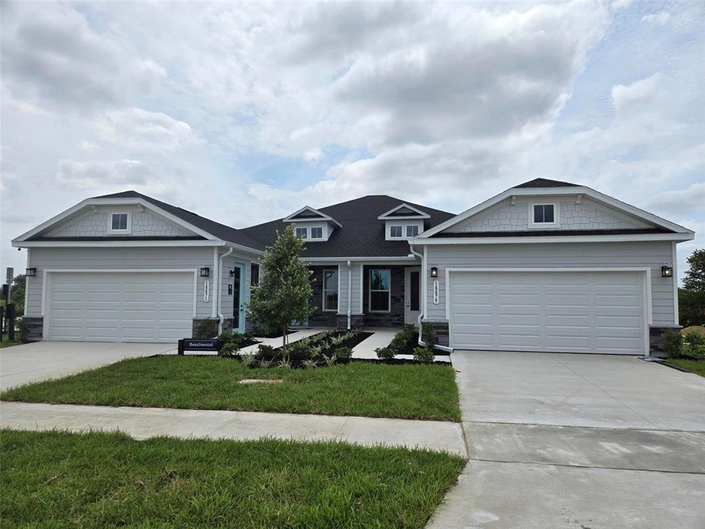 A light blue front door with a glass panel is set against a gray stone wall — 18716 HIGHLAND DEW STREET, SPRING HILL, FL