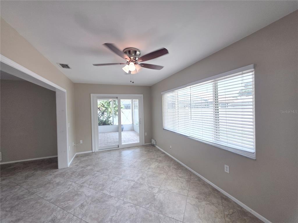A dining room features tile flooring, a ceiling fan, and sliding glass doors to a patio — 352 PINE TREE ROAD, VENICE, FL