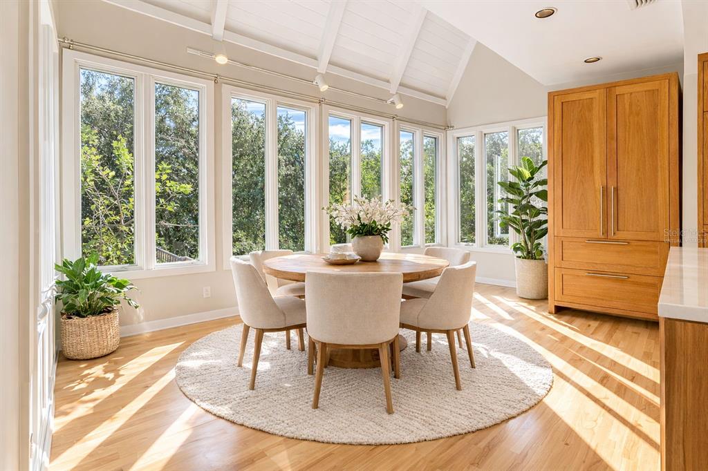 A bedroom features a bed, armchair, dresser, and vaulted ceiling with a ceiling fan — 1351 WILLOW BROOK DR, PALM HARBOR, FL
