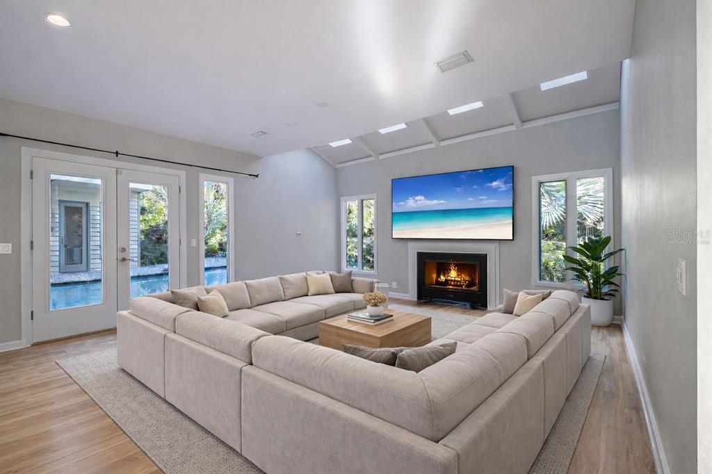 A large backyard features a grassy lawn, mature trees, and a house with a pool — 1351 WILLOW BROOK DR, PALM HARBOR, FL