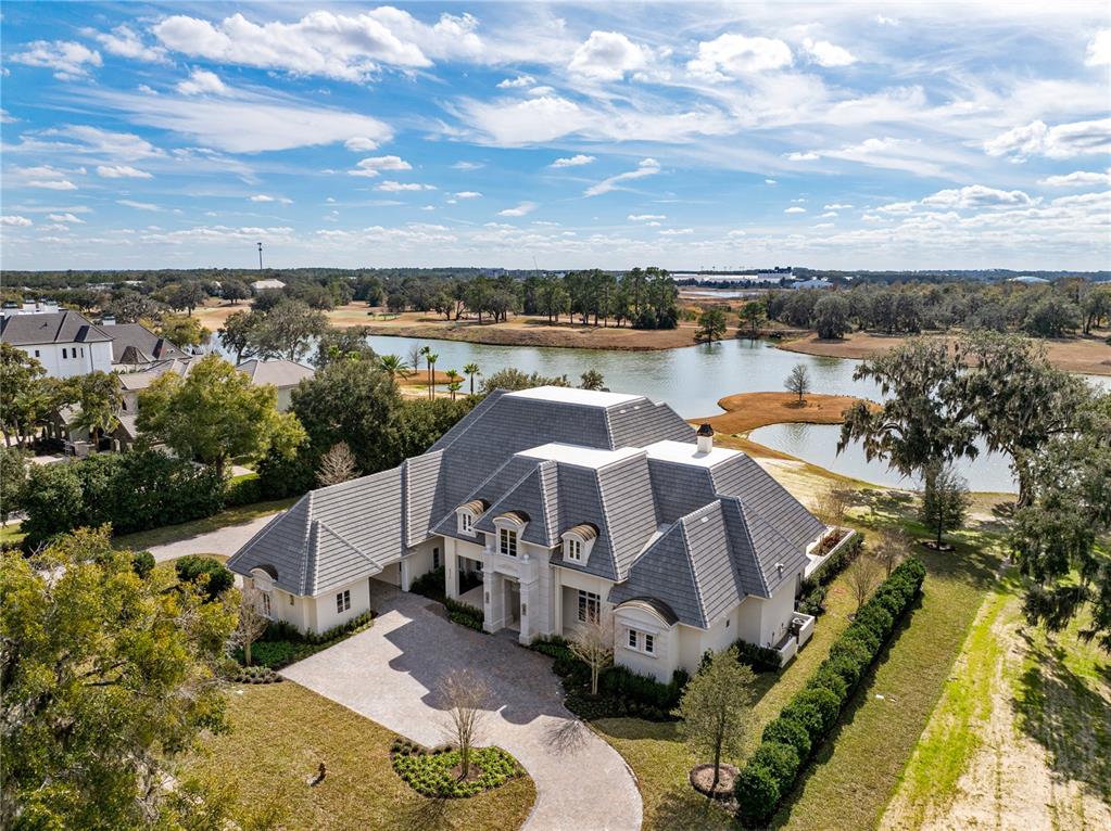 An aerial view of a large, multi-gabled house with a stone facade and tiled roof — 8570 NW 31ST LANE ROAD, OCALA, FL