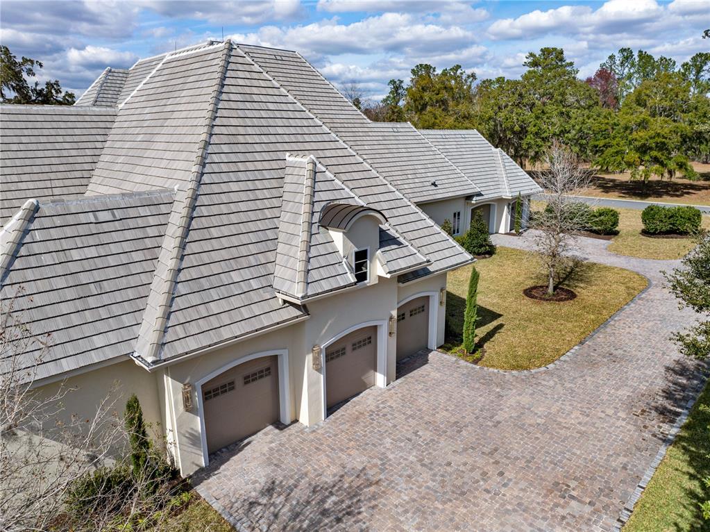 An aerial view of a house with a multi-car garage and a paved driveway — 8570 NW 31ST LANE ROAD, OCALA, FL