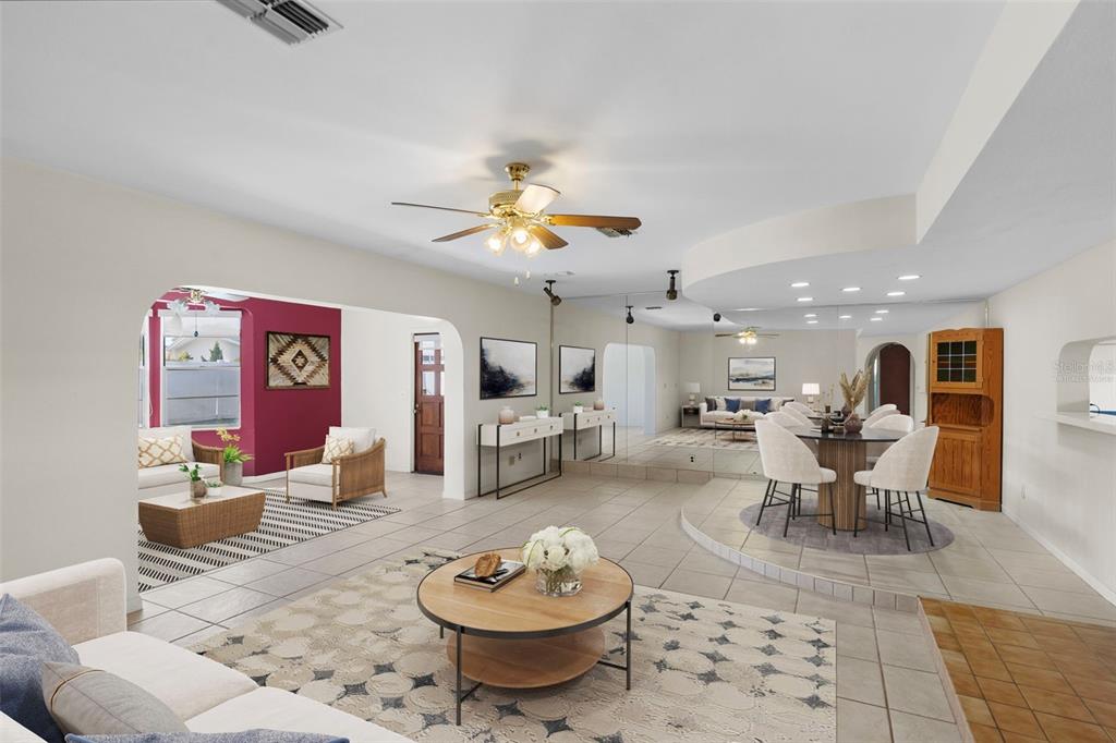 A spacious living and dining area with tile floors, a raised dining platform, and mirrors — 1768 HARBOR CIRCLE E, LARGO, FL