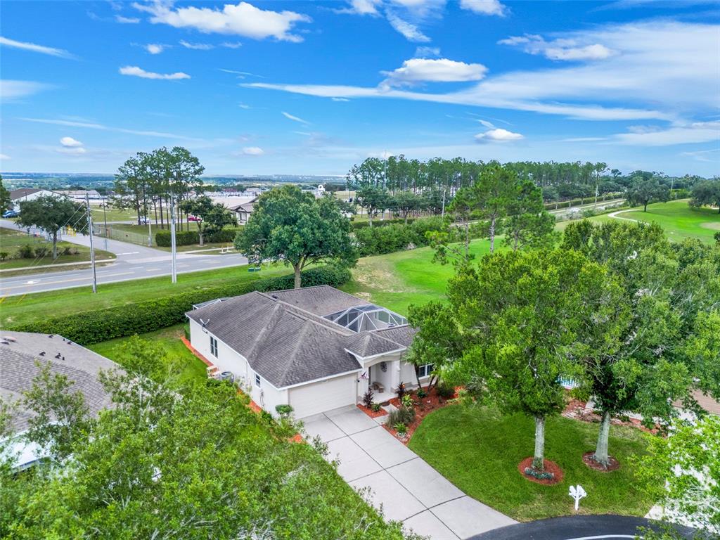 An aerial view of a single-story house with a screened-in pool and a concrete driveway — 2525 NEW CASTLE COURT, CLERMONT, FL