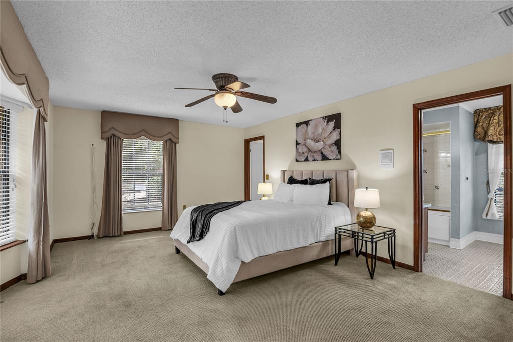 A bedroom features a bed, two nightstands, a ceiling fan, and an attached bathroom — 1111 AUDUBON WAY, MAITLAND, FL