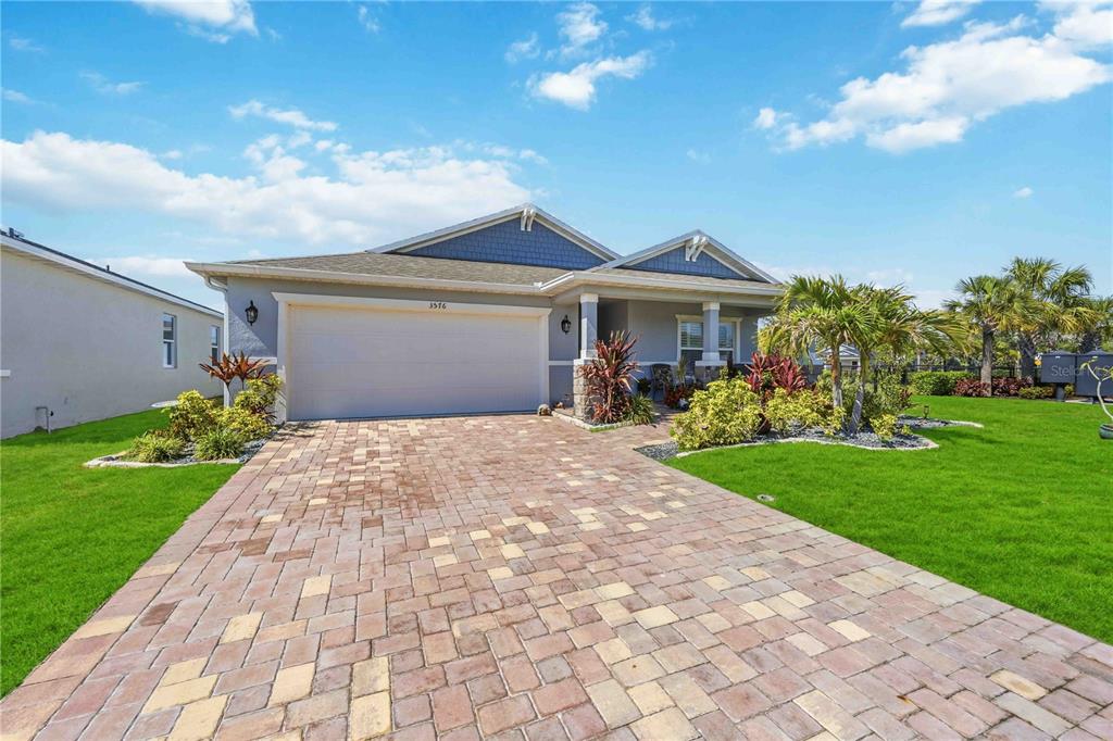 A single-story house with a blue facade, a two-car garage, and a paved driveway — 3576 74TH AVENUE CIRCLE E, SARASOTA, FL