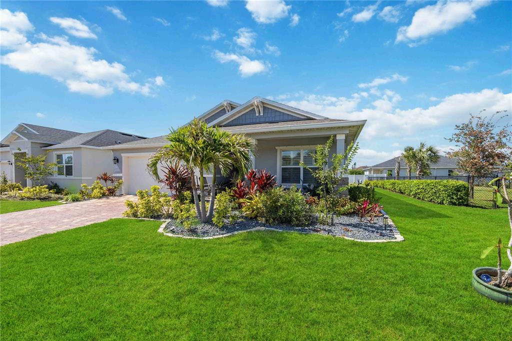 A single-story house with a gray exterior, a paved driveway, and landscaped front yard — 3576 74TH AVENUE CIRCLE E, SARASOTA, FL