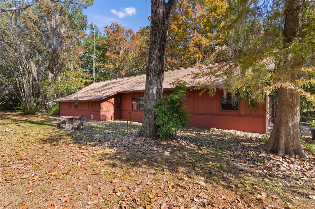 The exterior of a brown, single-story house is surrounded by trees and fallen leaves — 6250 & 5942 E C 478, CENTER HILL, FL