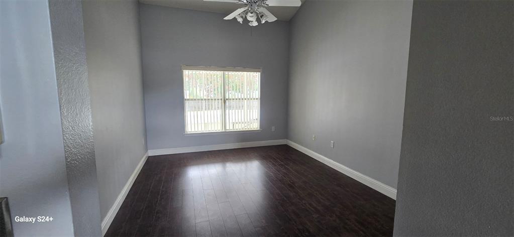 An empty room with light gray walls, dark wood flooring, and a ceiling fan — 131 CLOWSON COURT, OCOEE, FL