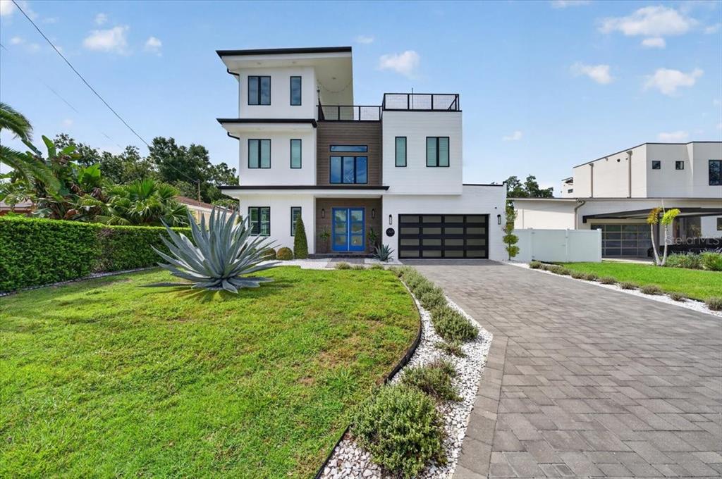 A modern white two-story house features a backyard swimming pool with an attached spa — 1308 W PLYMOUTH STREET, TAMPA, FL