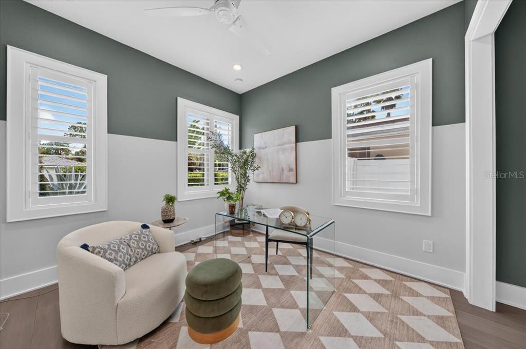 A home office features a glass desk, a cream armchair, and two-toned gray and white walls — 1308 W PLYMOUTH STREET, TAMPA, FL