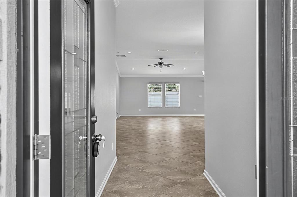 A view through an open front door into a tiled foyer and living area — 5 GRAHAM TRAIL, PALM COAST, FL