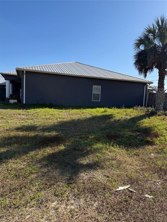 A side view of a dark gray house with a metal roof and one window — 2904 JUNIPER DRIVE, EDGEWATER, FL
