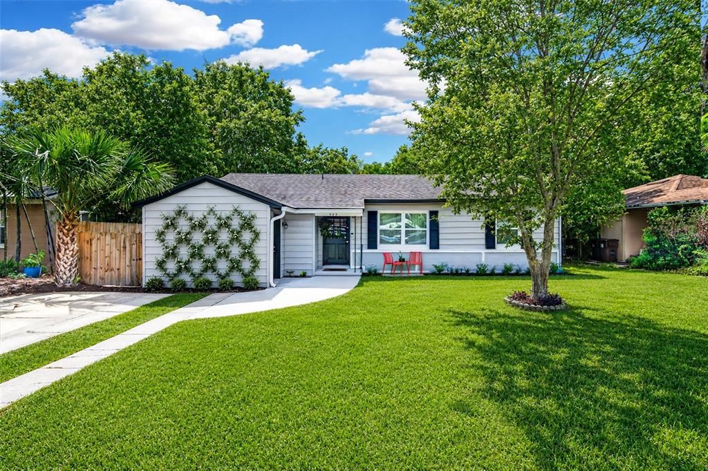 A gray house exterior features a black front door, a concrete walkway, and two chairs — 212 S GLENWOOD AVENUE, ORLANDO, FL