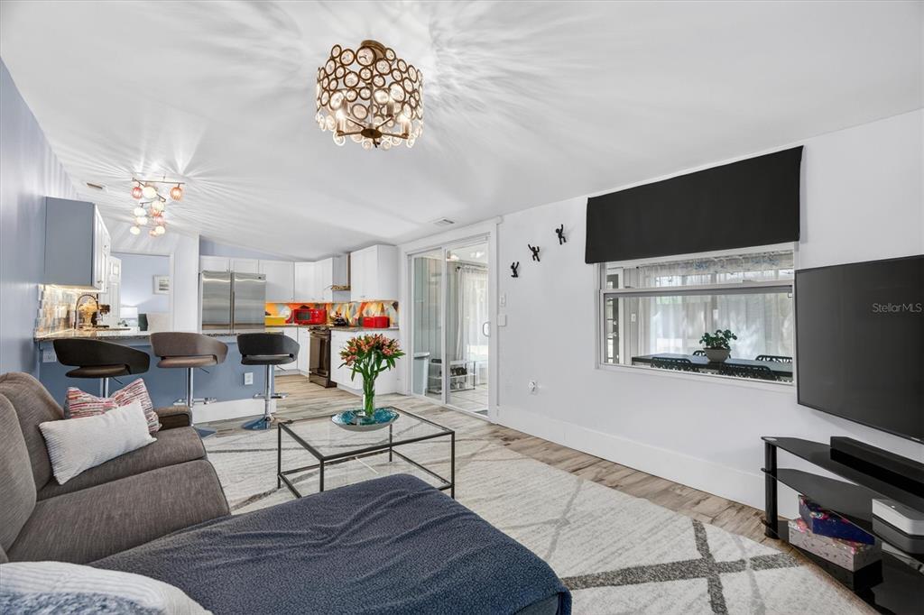 A kitchen with white cabinets, granite countertops, a colorful geometric backsplash, and wood-look flooring — 212 S GLENWOOD AVENUE, ORLANDO, FL